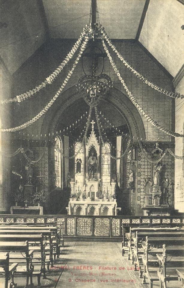 The chapel nave hung with garlands from the vault, the pews lined up before the great carved altar and its statues.