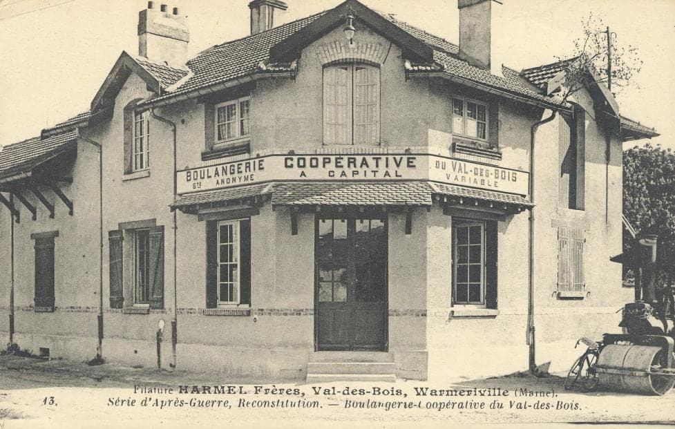 The new building of the cooperative bakery, gabled and shuttered, with its sign “Boulangerie coopérative, société anonyme à capital variable du Val-des-Bois”.