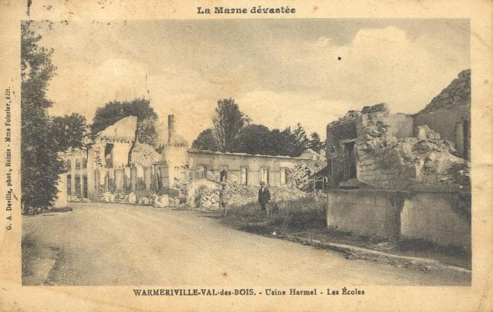 The Val-des-Bois schools in ruins along a road: gutted walls, roofs gone; a passer-by stands among the rubble.