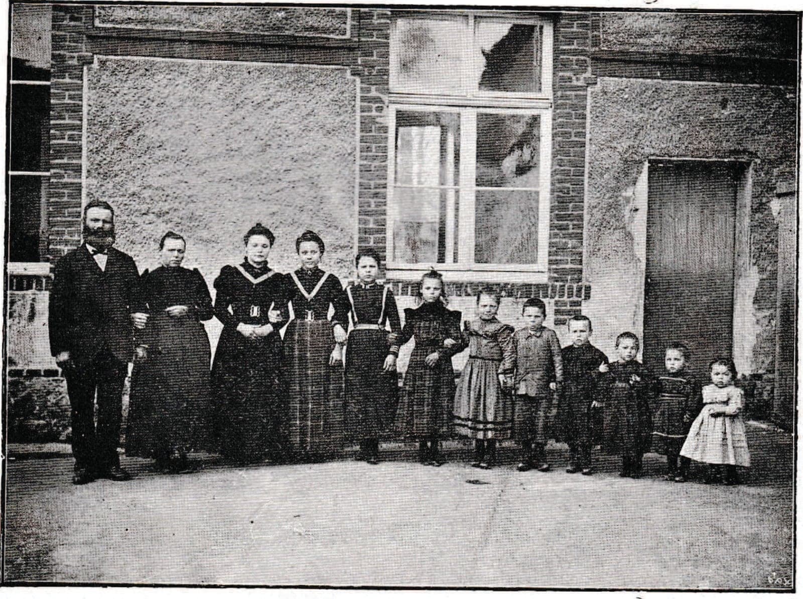 A bearded father and his many children, from young women to the smallest, lined up by height along a brick wall; the brochure uses it to illustrate the family wage.