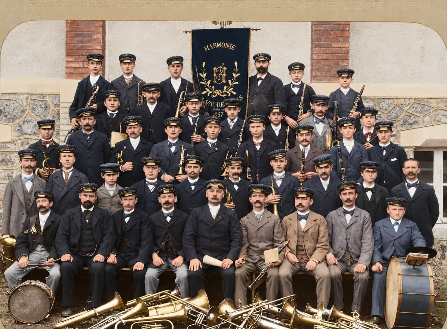 About forty musicians in caps pose around their “Harmonie” banner, with their instruments set down in front of them.