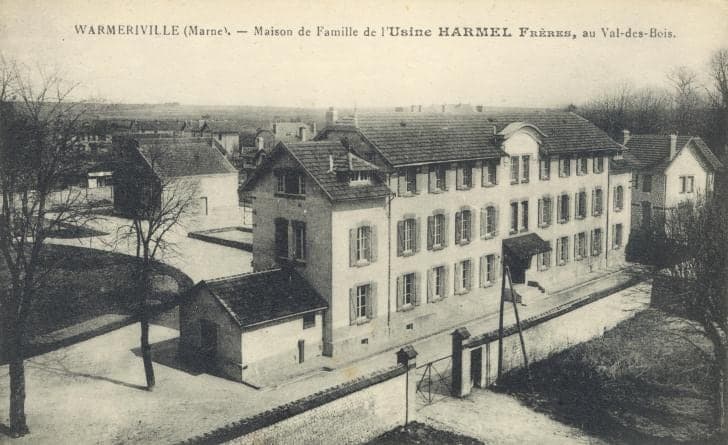 A view from above of the family house, a large three-storey building with a mansard roof, surrounded by outbuildings and a courtyard closed by railings.