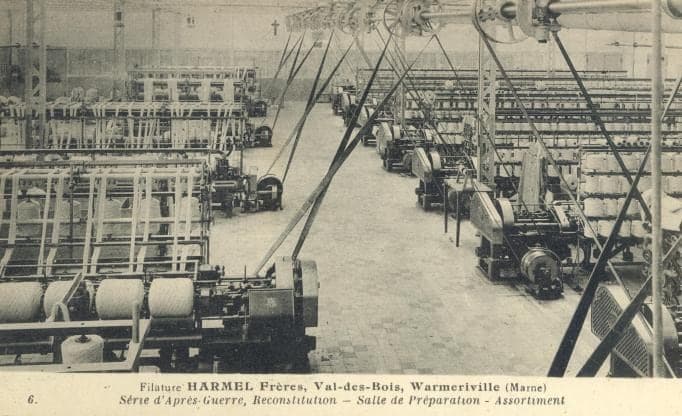 The bright preparation room of the rebuilt mill, with its new machines in rows and their wool bobbins.