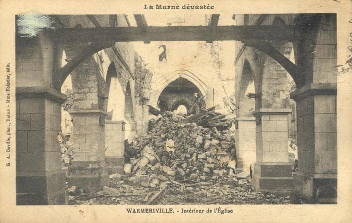 The nave of Warmeriville church choked with rubble up to the choir, beneath arches propped with beams.